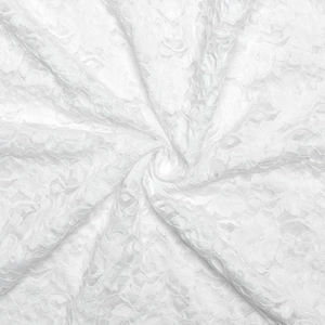 Detailed close-up of white floral lace fabric with delicate mesh texture and sheer finish