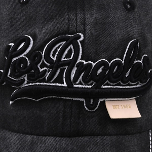Detailed macro of 3D Los Angeles embroidery and leather patch on vintage baseball cap