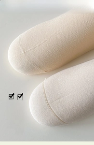 Detailed macro view of seamless toe stitching on beige combed cotton tulip socks
