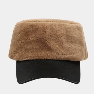 Winter plush navy hat in brown faux fur with black leather brim against gray background