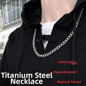Detail of silver stainless steel Cuban link chain necklace on a black hoodie base