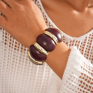 Close-up of wide stretch bracelet with purple oval beads and gold metallic spacers