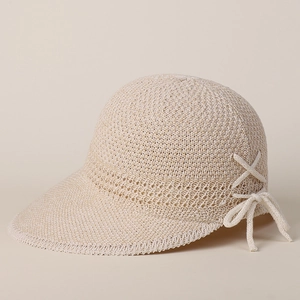 Dettaglio del cappello da sole in maglia beige con trama intrecciata e fiocco decorativo
