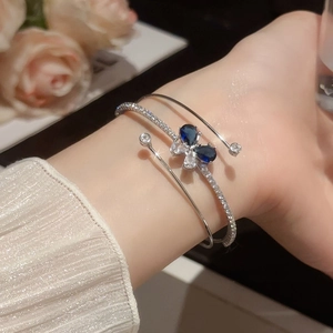 Dettaglio del bracciale a tre strati in argento con farfalla di zirconi blu