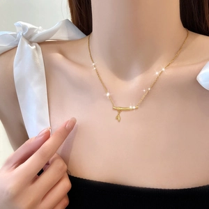 Minimalist gold titanium steel bamboo necklace shown on model neck with leaf pendant