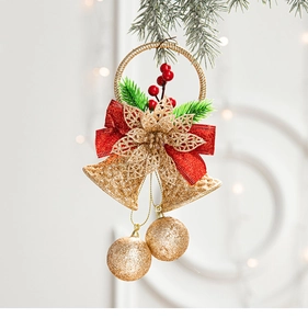 Close-up of gold Christmas bells with red velvet bow and pine needles on tree branch