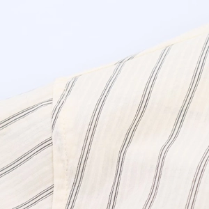 Detailed macro view showing striped fabric texture and stitching of a vintage loose shirt