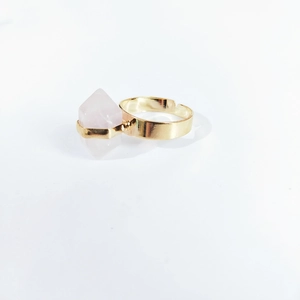 Detail view of pink hexagonal crystal stone set on a golden adjustable open ring band
