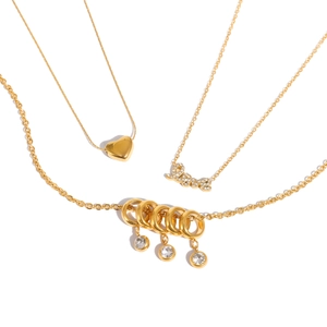 Trois colliers en acier plaqué or 18k avec pendentifs cœur, Love et pierres fines