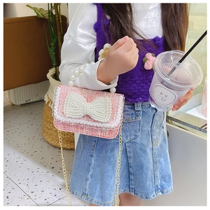 Détail du sac à main rose en tweed pour fille avec nœud en perles et chaîne dorée