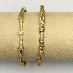 Vista macro di braccialetti placcati in oro con micro-pave di zirconi su supporto tondo