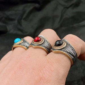 Détail de trois bagues vintage en acier avec pierres bleues rouges et noires