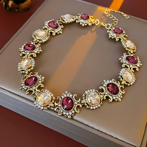 Detail of vintage golden necklace with purple and champagne crystals in a gift box