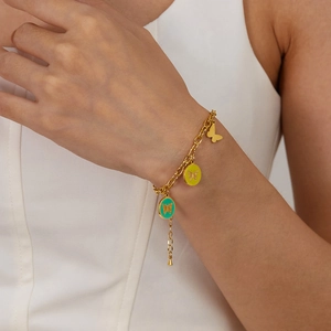Gold stainless steel butterfly bracelet with colorful enamel pendants on woman's wrist