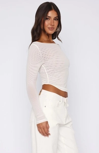 Detail of white mesh off-shoulder crop top showing long sleeves and sheer fabric texture