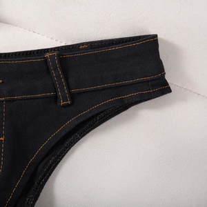 Gros plan sur le short en jean noir avec surpiqûres orange et boucles de taille renforcées