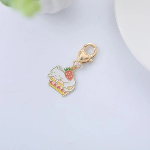 Close-up of white cat on strawberry cake enamel charm with heart spring clasp