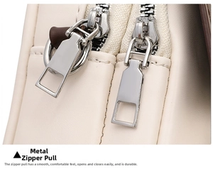 Detailed close-up of smooth dual silver zippers on cream leather crossbody bag