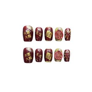 Red and gold press-on nails with 3D characters for Lunar New Year celebration
