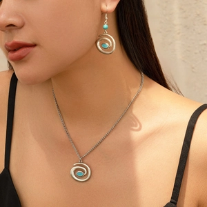 Detailed close-up of ethnic turquoise necklace and earring set on a female model