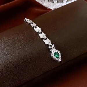 Elegant silver snake chain bracelet with green pear-shaped gemstone and white zircons