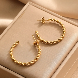 Elegant gold twisted hoop earrings with textured rope design displayed on silk
