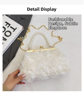 Détail de pochette blanche avec roses en tissu, anse en perles et chaîne dorée