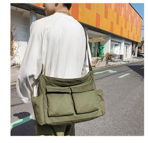 Macro view of army green canvas messenger bag with large front pockets and utility style