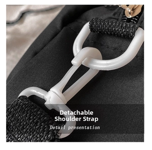 Detail showing the detachable white strap hook and black fabric of the canvas bag