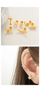 Detailed set of gold titanium cartilage studs with moon and star zircon accents