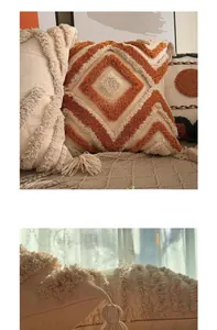 Detail of bohemian tufted cushion cover featuring orange geometric patterns and tassels