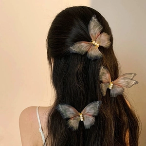 Three elegant tulle butterfly hair clips with pearls on model's long dark hair