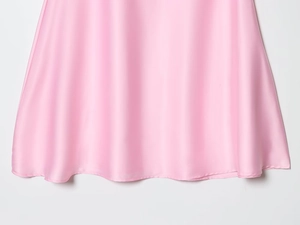 Detailed view of pink satin fabric texture with smooth silky finish and soft drapes