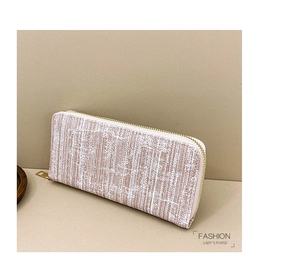 Close-up of pink and white tweed texture on a long wallet with a gold zipper detail