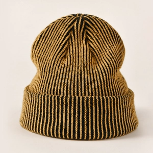 Close-up of yellow and black striped knit beanie with thick ribbed cuff and fine stitching