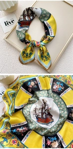 Detailed pattern of silk scarf featuring nautical sailing ships and floral scrolls