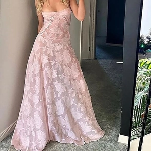 Détail du tissu en dentelle florale rose et mesh sur une élégante robe de soirée longue