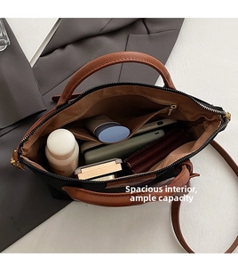 Macro view showing the spacious interior of the black nylon tote bag with brown lining