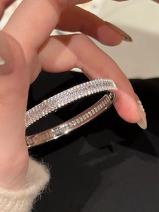 Gros plan sur un bracelet luxe argenté orné de rangées denses de zircons étincelants