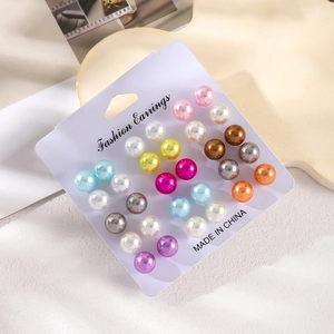 Detailed view of 12 pairs of colorful round pearl stud earrings on display card