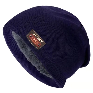 Detail of navy knit beanie showing thick grey fleece lining and sport leather patch