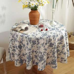 Detail of blue floral print on linen tablecloth with elegant fringe trim and home decor