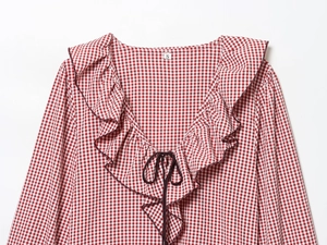 Detail of red gingham shirt showing ruffled V-neckline, tie strings, and size S label