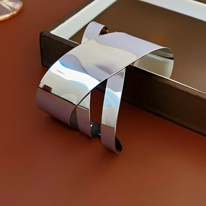 Detailed view of wide silver irregular metal cuff bracelet with minimalist layered design