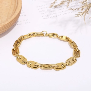 Golden stainless steel coffee bean link bracelet on minimalist white background with dried flower