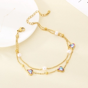 Detail of 18K gold double-layer anklet with purple crystal hearts and white pearls