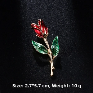 Detailed macro view of vintage rose brooch with red enamel petals and gold frame