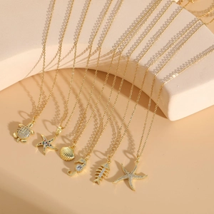 Detailed group shot of ocean-themed gold necklaces with shell and starfish pendants