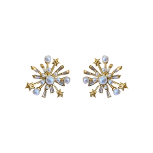 Elegant gold flower star stud earrings with white pearls and sparkling zircons on white backdrop