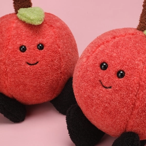 Close-up of plush apple fruit pillows featuring soft sherpa fabric and cute smiling faces